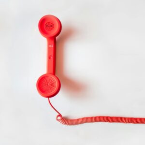 Red Corded Telephone on White Suraface